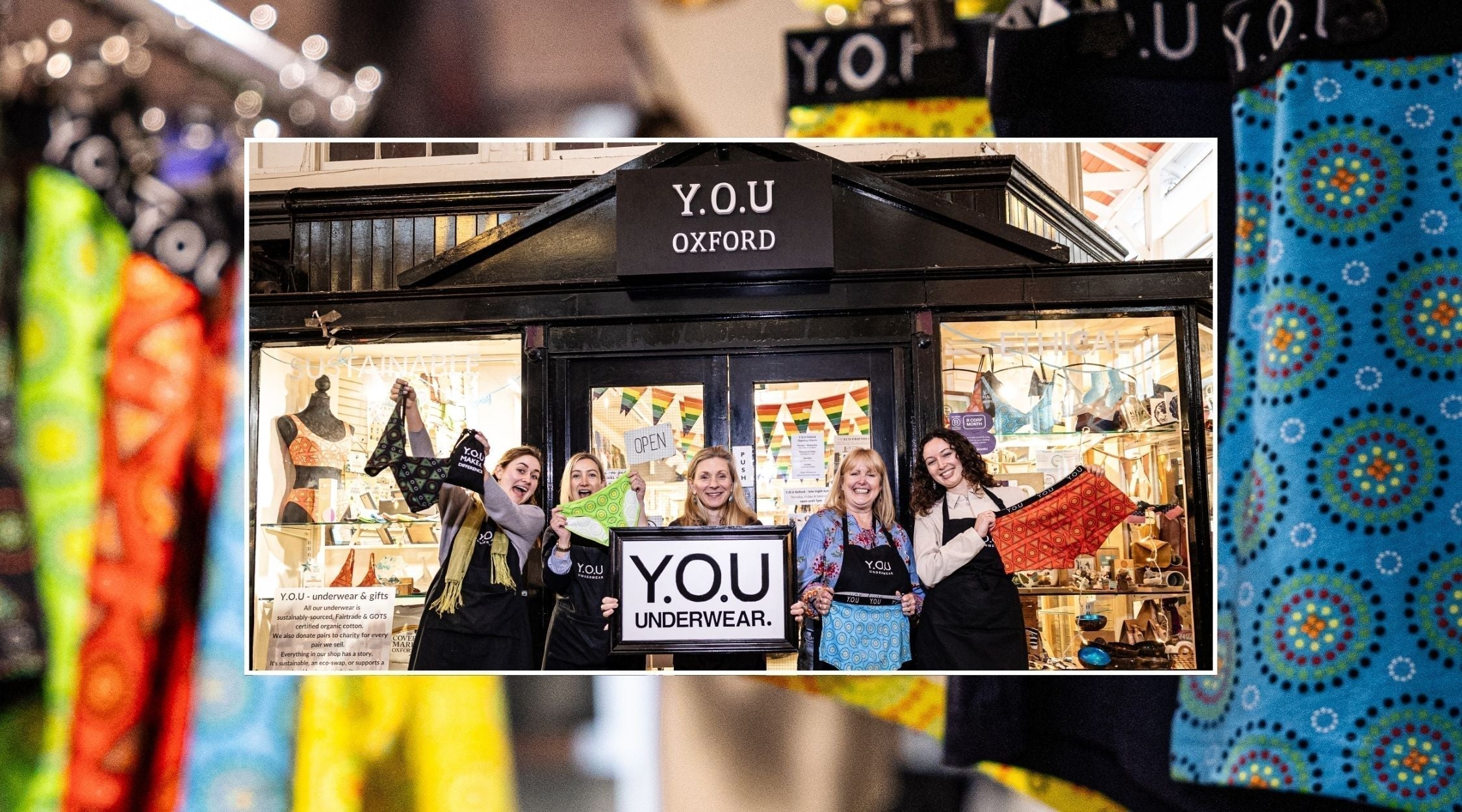 five women pose outside a shop holding up brightly coloured underwear and a Y.O.U Underwear logo sign. the image is laid over a close up image of mara print underwear