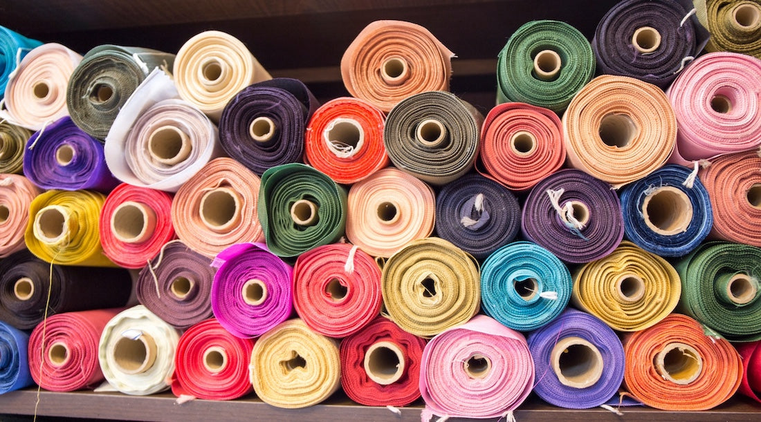 rolls of colourful fabric piled up together.