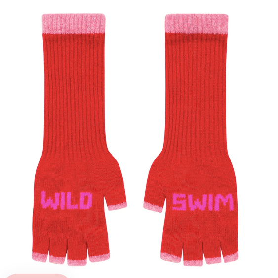 A flat lay photo of the Black & Beech Wild Swim fingerless gloves in bright red with neon pink writing and light pink cuffs on a white background.