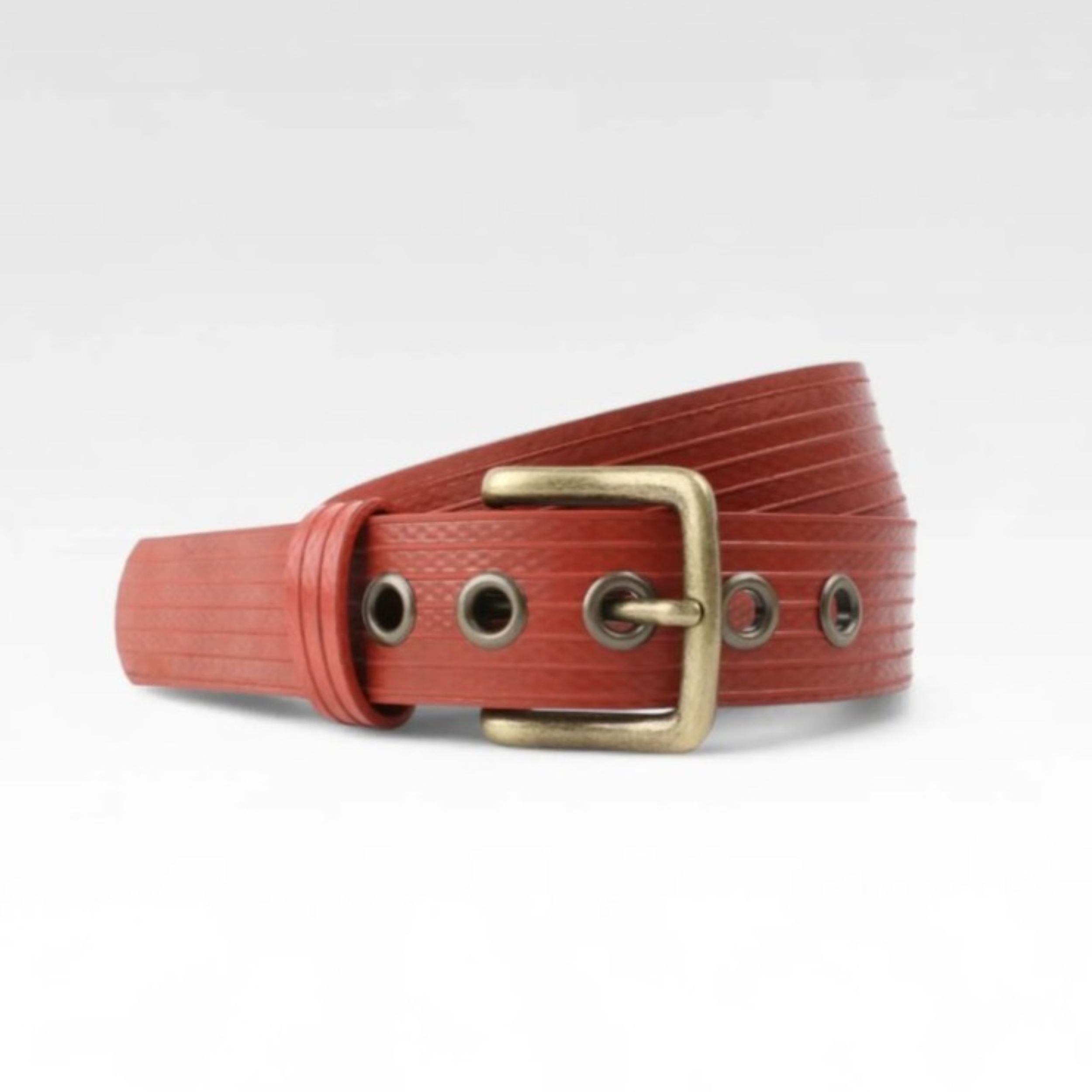 A photo of the Elvis & Kresse red West End belt wrapped into a circle on a white background
