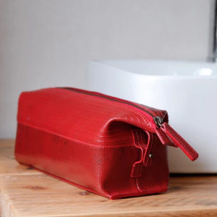 Elvis and Kresse medium red washbag on a wooden table next to a bathroom sink