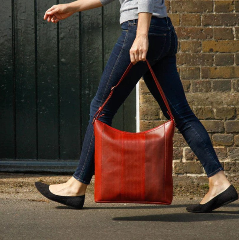 The Elvis and Kresse Tooley Tote Bag being held by a model walking past a brick wall