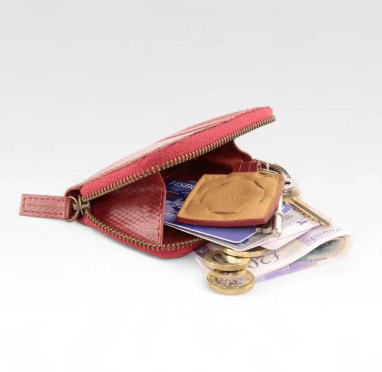 Elvis and Kresse red coin pouch open with cash spilling out on a white background
