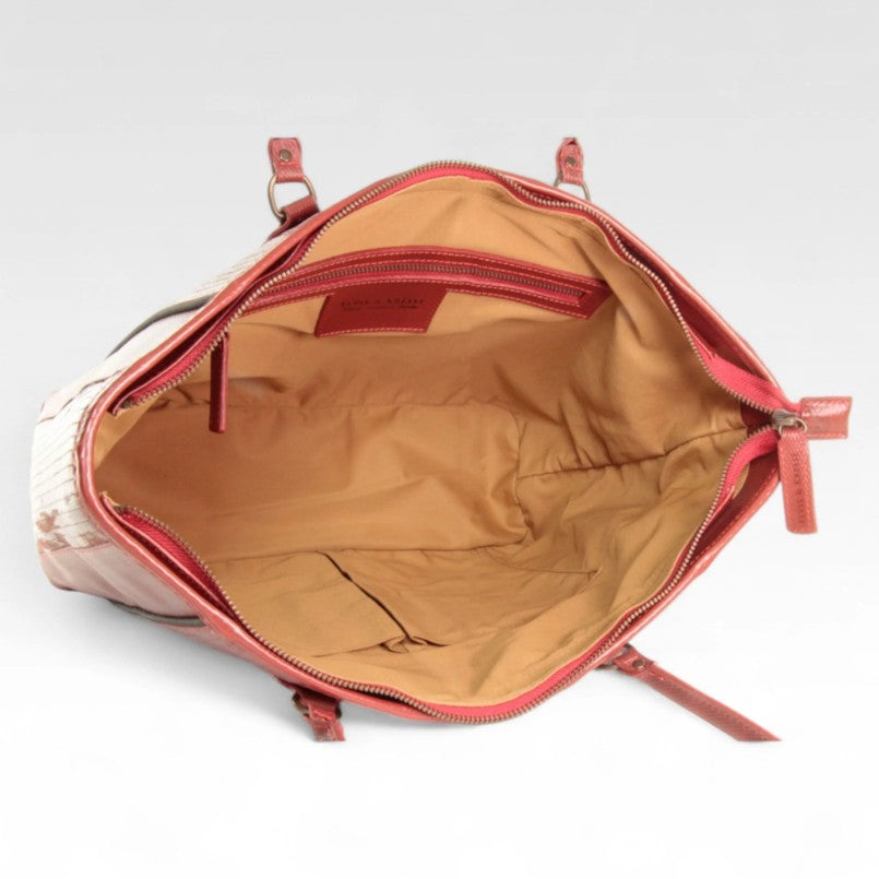 The red Elvis and Kresse Tote Bag on its side, showing the inside of the bag on a white background