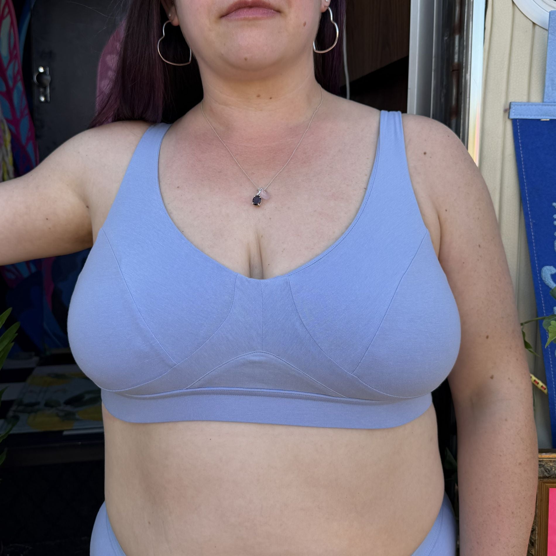 A photo of a model wearing the YOU Underwear non-wired bra in light blue. The photo is zoomed in so we can see from the model's chin to her hips. She is facing the camera.