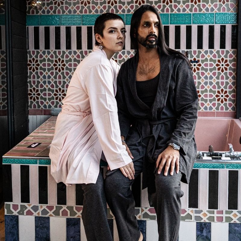 Man and woman wearing robes in charcoal grey and light pink