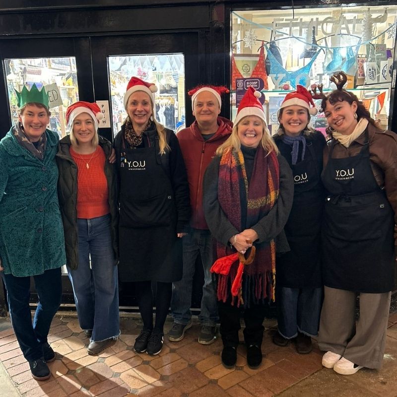 the YOU Oxford team standing outside the shop wearing Santa hats.