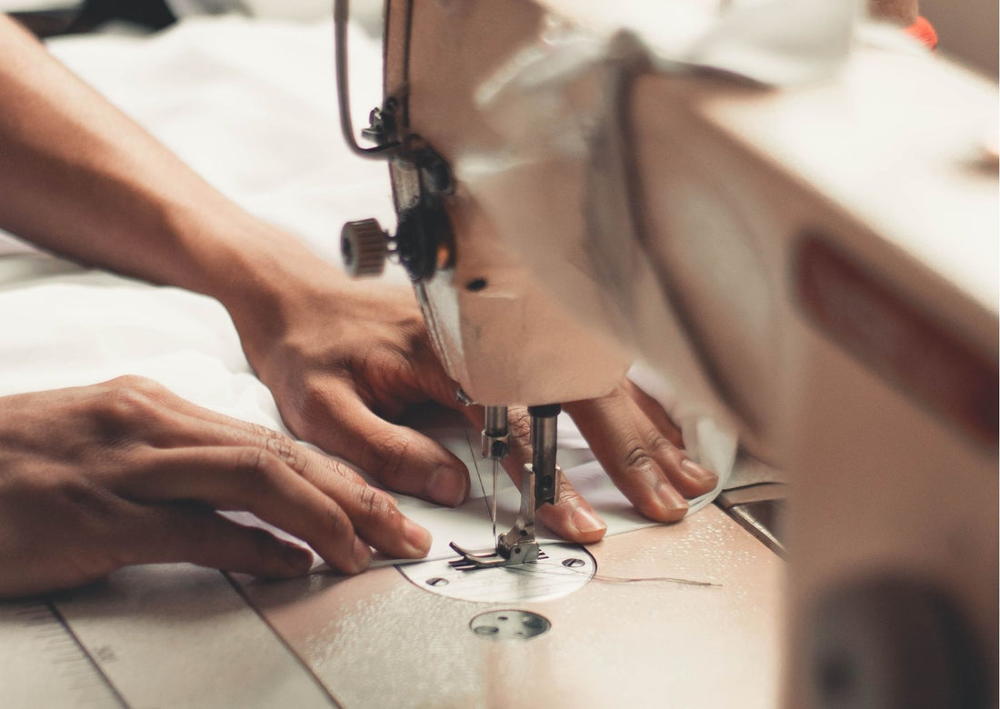 A pair of hands work at a sewing machine
