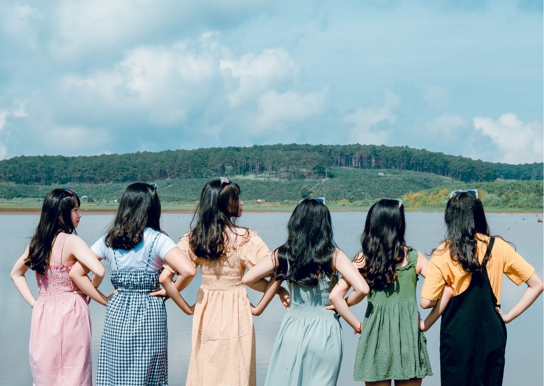 Row of girls holding hands and looking out at the lake