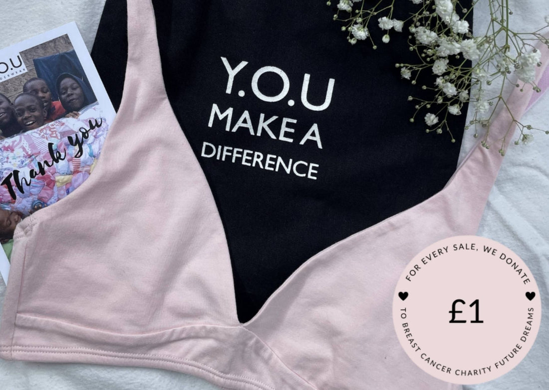 Our Light Pink Organic Cotton Bralette is on top of our 'Y.O.U Make A Difference' organic cotton black bag, there are white budded flowers in the top right corner 