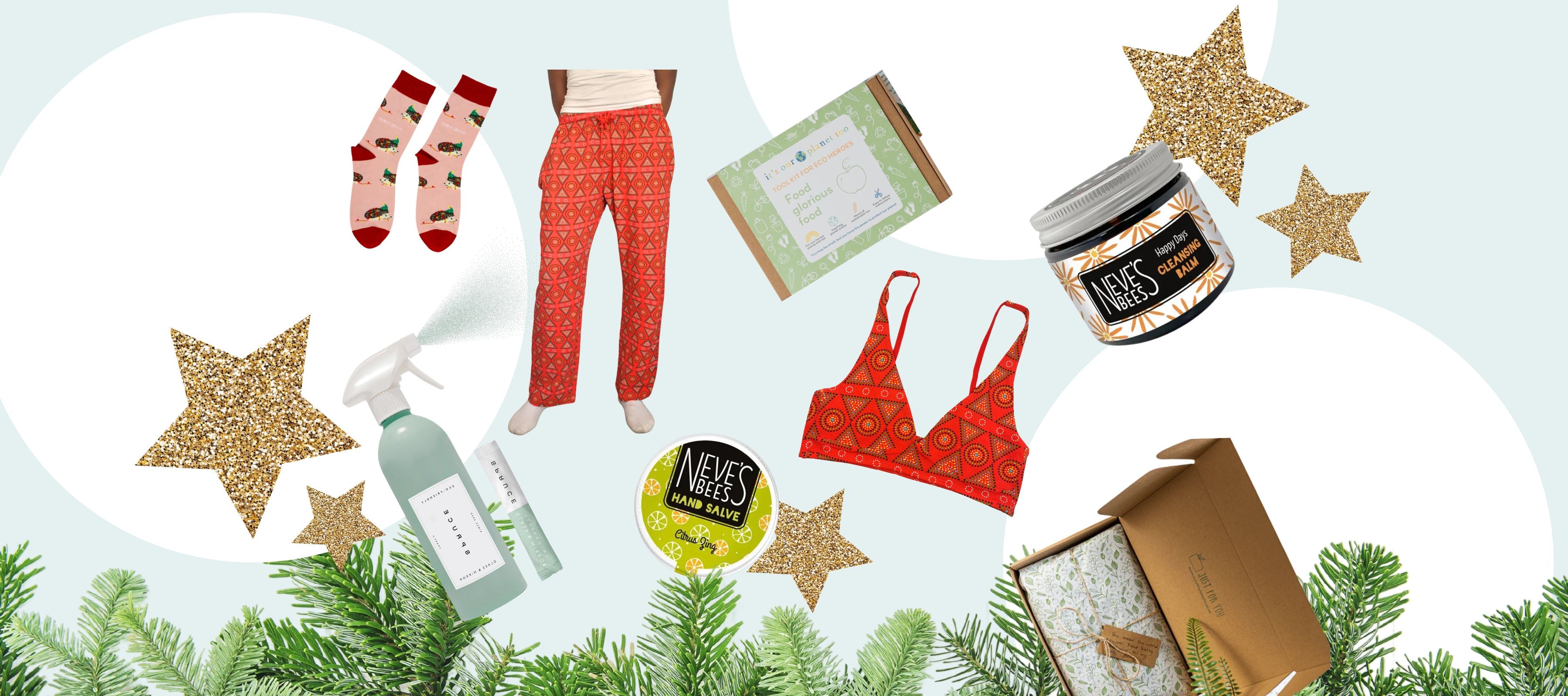 A selection of festive gifts scattered over a blue background with Christmas foliage. 