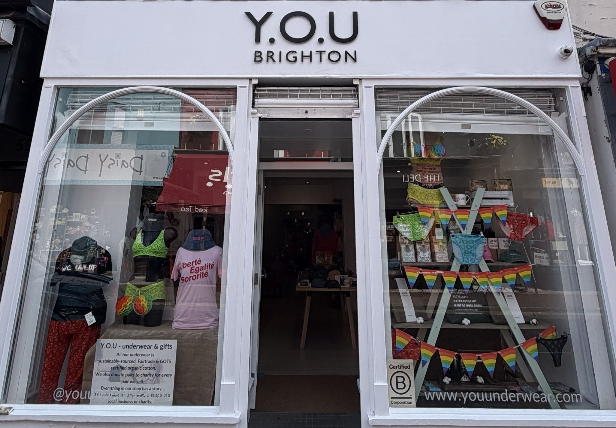 A shopfront with a YOU Brighton sign above it and some colourful underwear in the windows. 