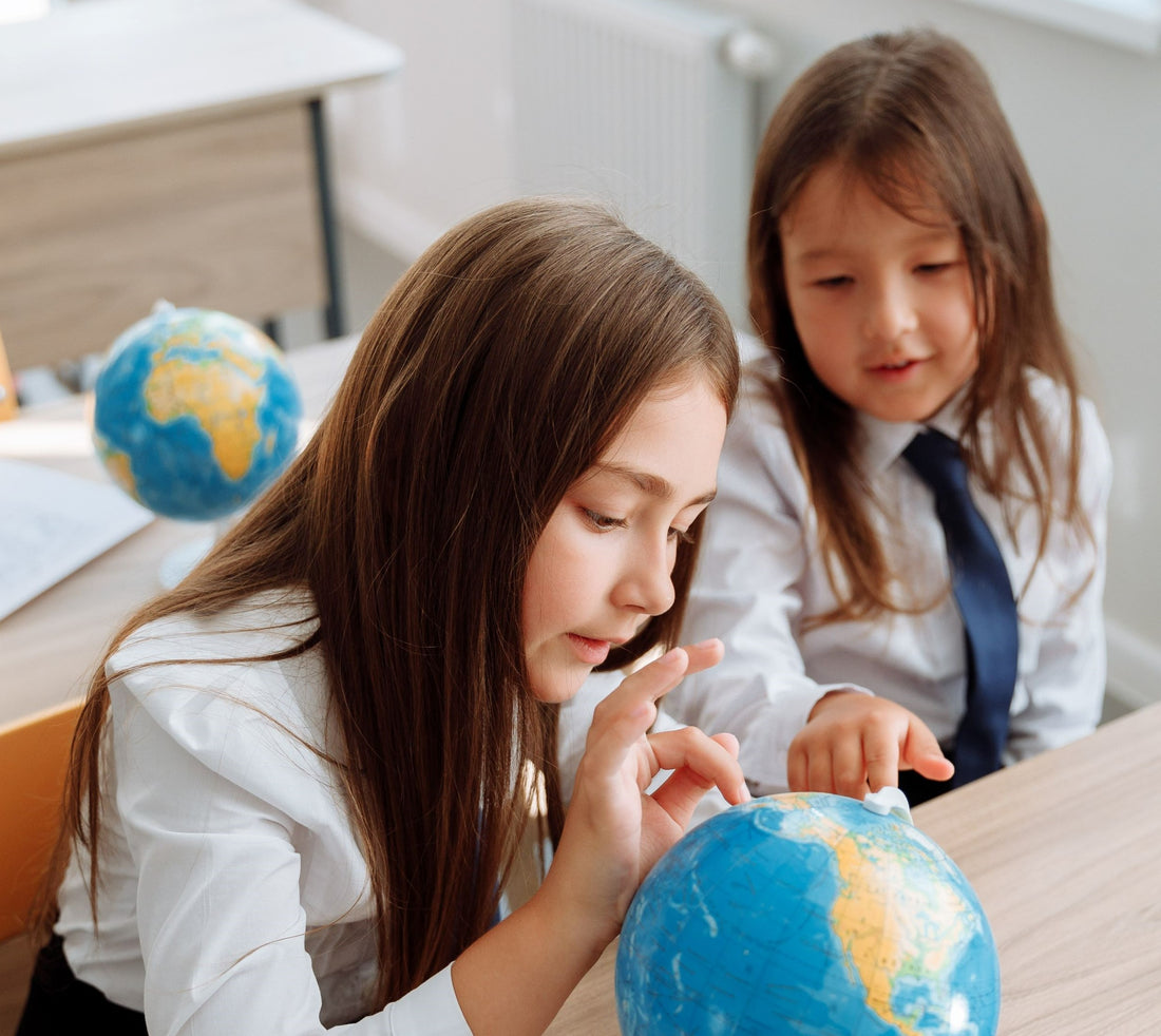 Two girls looking at a globe