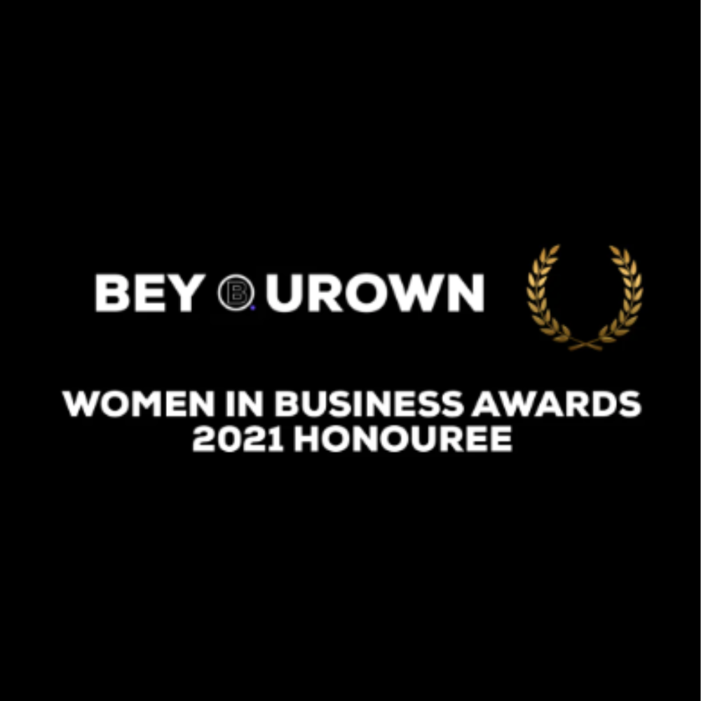 An image which reads, 'Be Your Own, Women in Business Awards 2021 Honouree.' The writing is in white on a black background. There is a gold leaf graphic on the right side of the image.