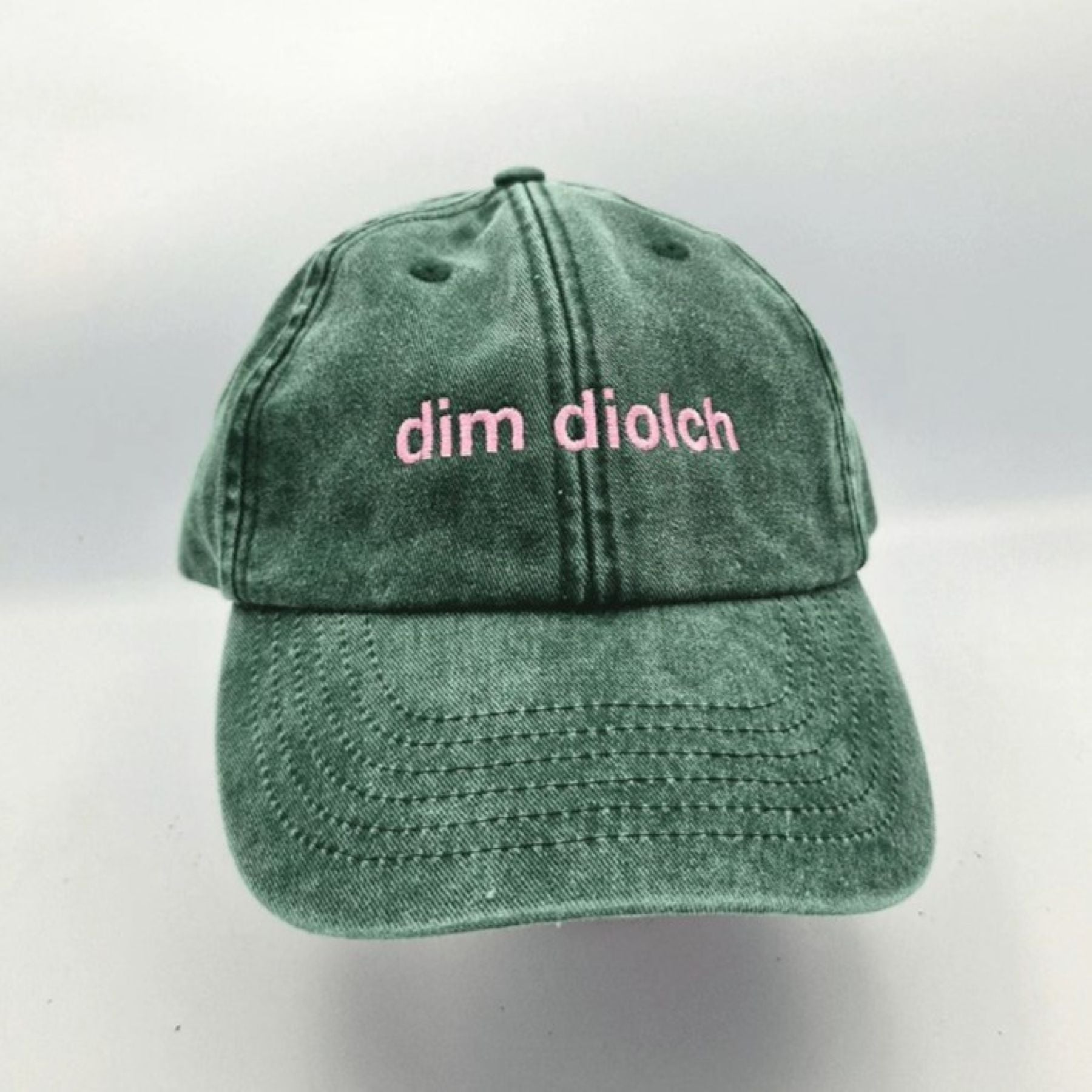 A photo of the Black & Beech Dim Diolch baseball cap in forest green on a white background
