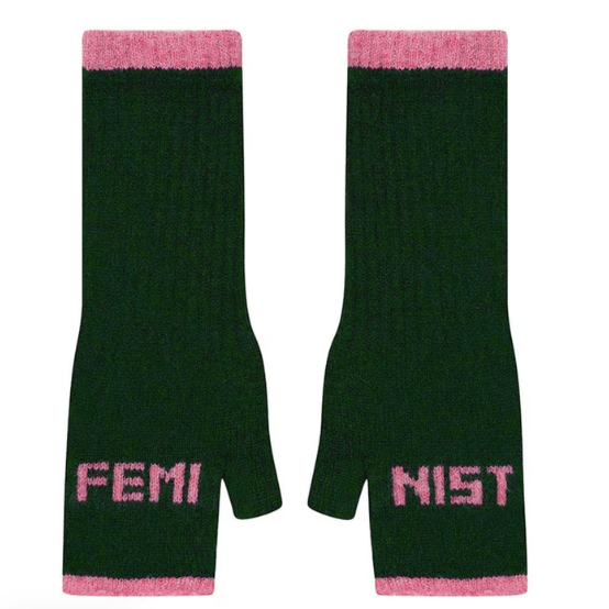 A flat lay photo of the Black & Beech Feminist Gloves in dark green with light pink writing and cuffs on a white background.