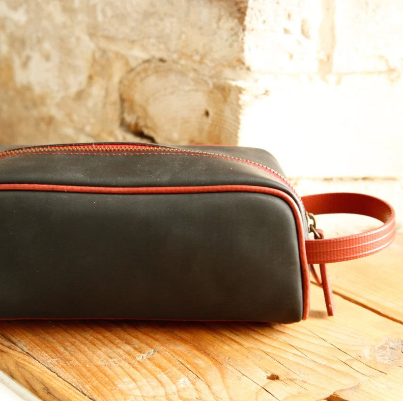 The Elvis and Kresse Black and Red Printing Blanket Travel Case on a wooden table