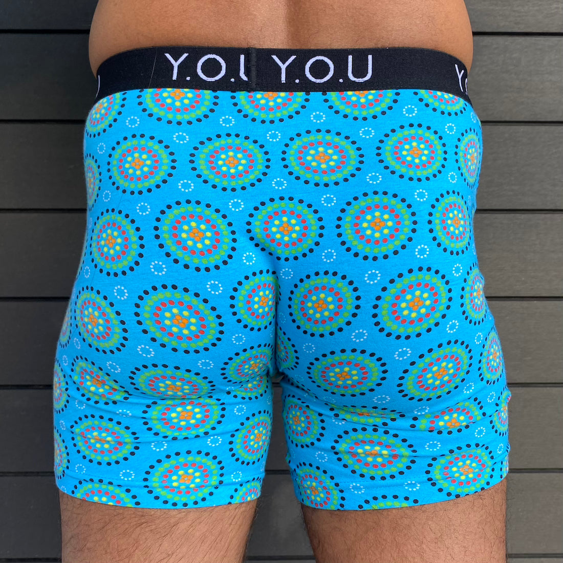 model wearing organic cotton longer leg style trunks in blue mara- You Underwear