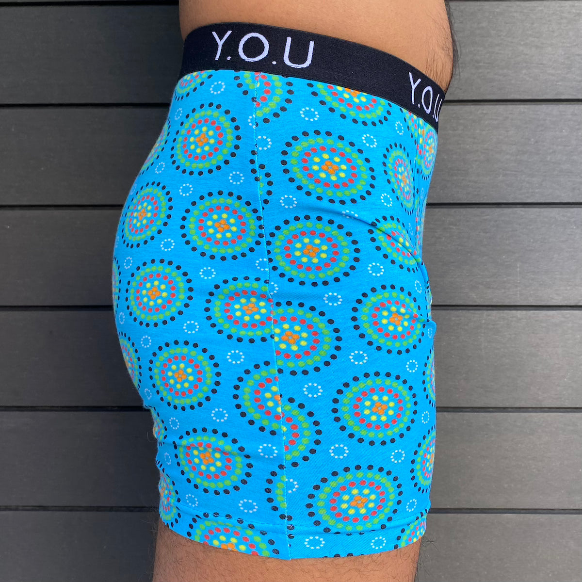 model wearing organic cotton longer leg style trunks in blue mara- You Underwear