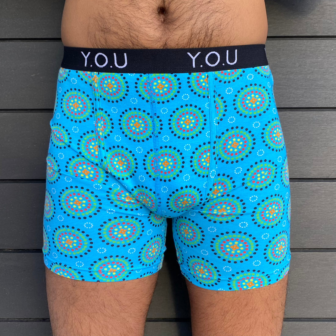 model wearing organic cotton longer leg style trunks in blue mara- You Underwear