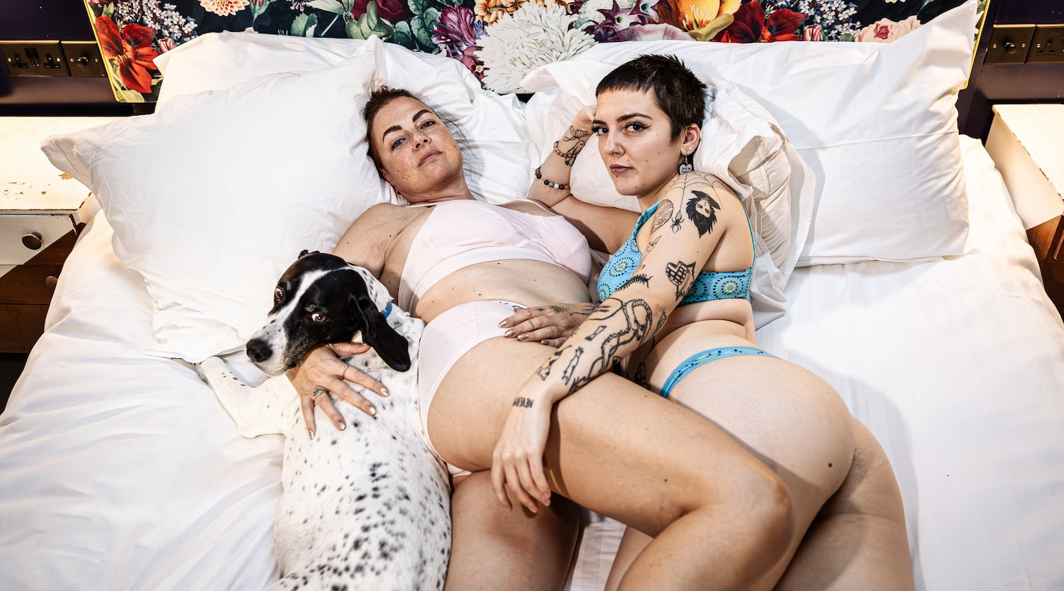 two models laying on a bed with white sheets wearing matching YOU sets