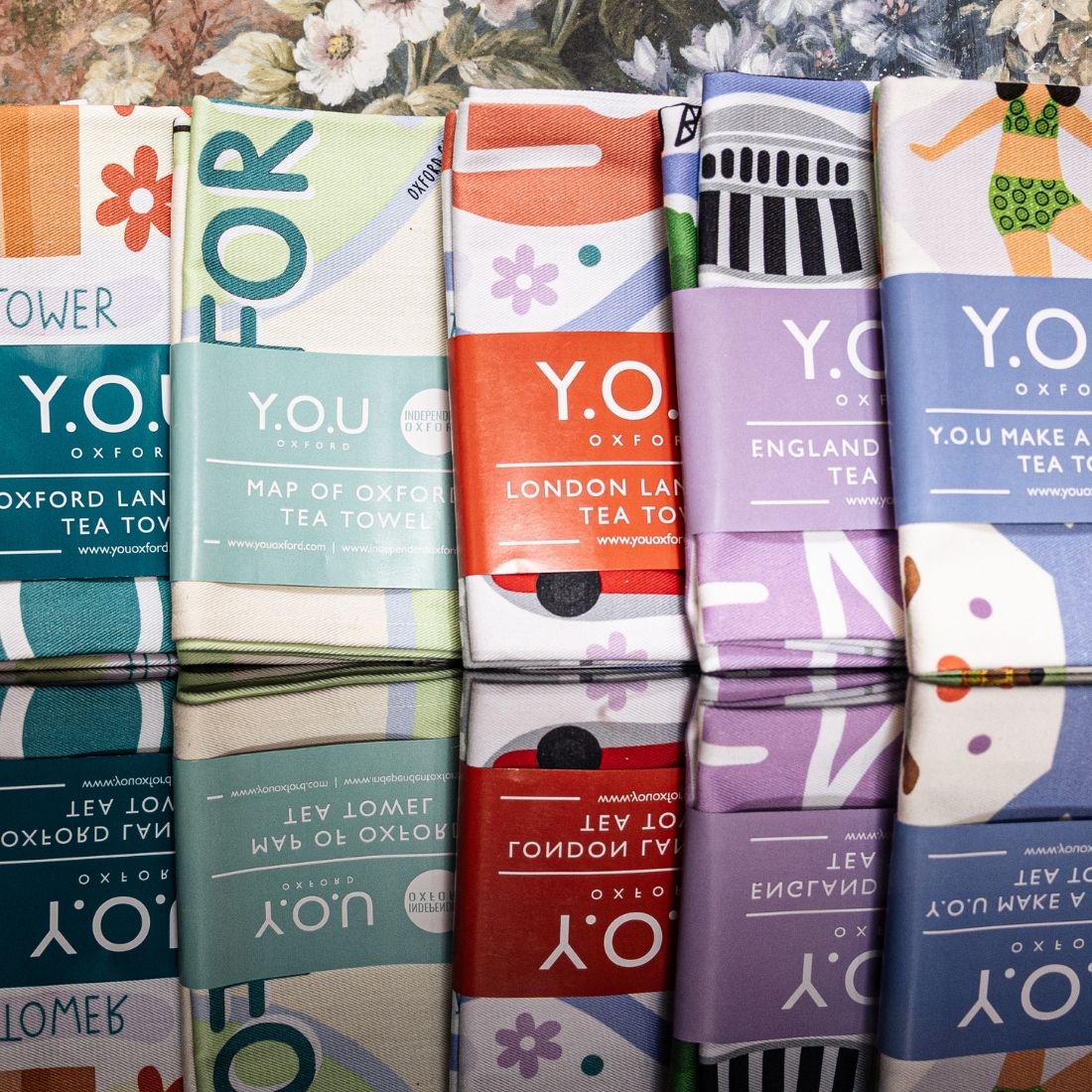 Organic cotton tea towels printed with illustrated designs of different cities and landmarks folded and displayed together - Y.O.U underwear