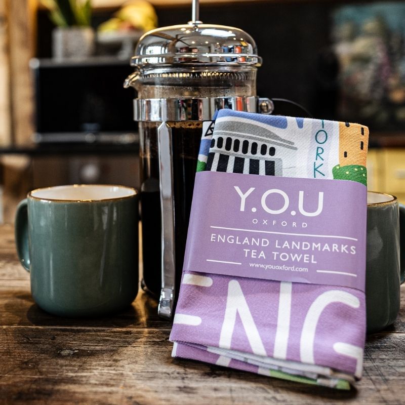 Organic cotton tea towel printed design with illustrations of England landmarks folded and wrapped with a paper band - You Underwear