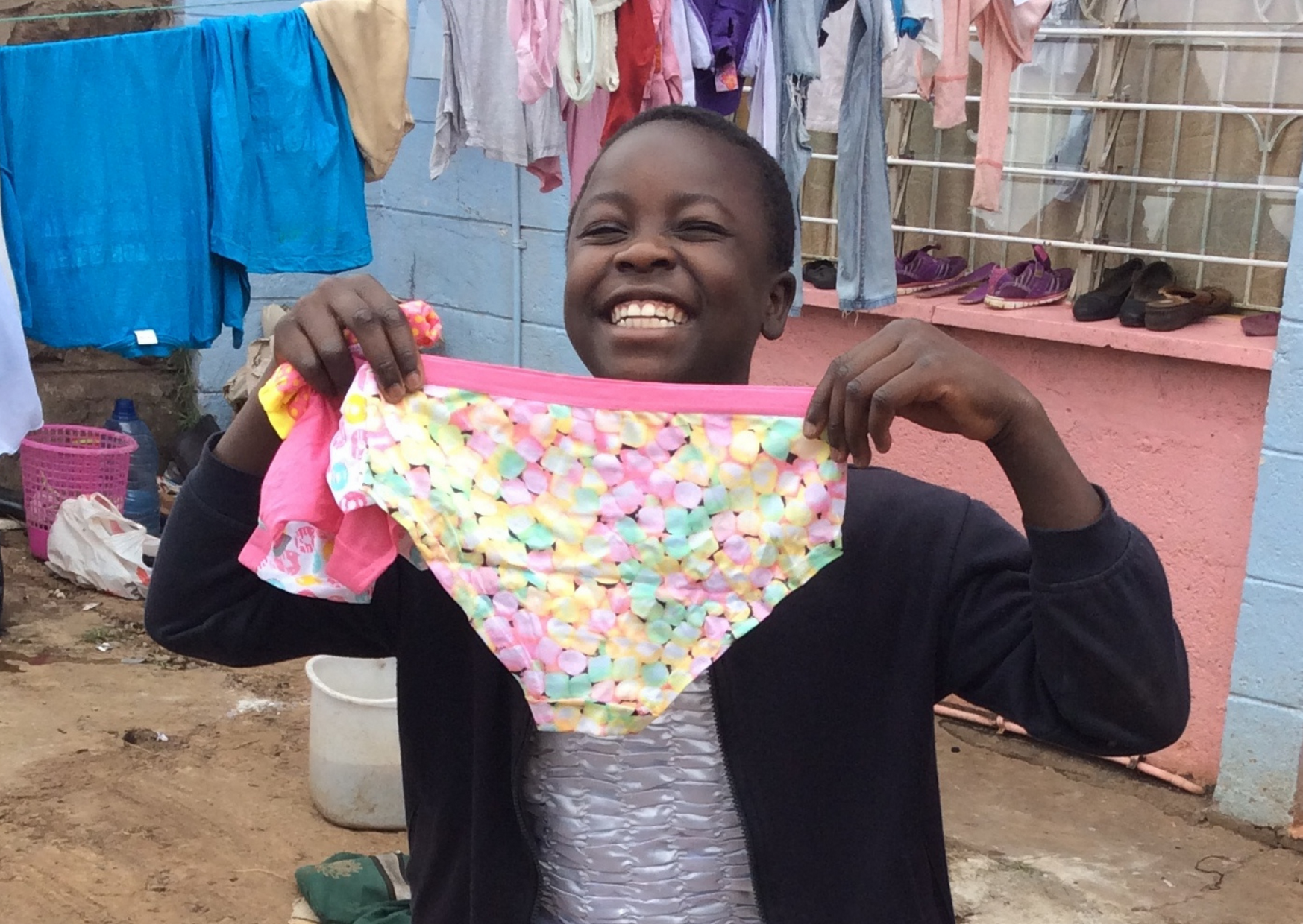  A child holds a pair of pants donated by Smalls for All