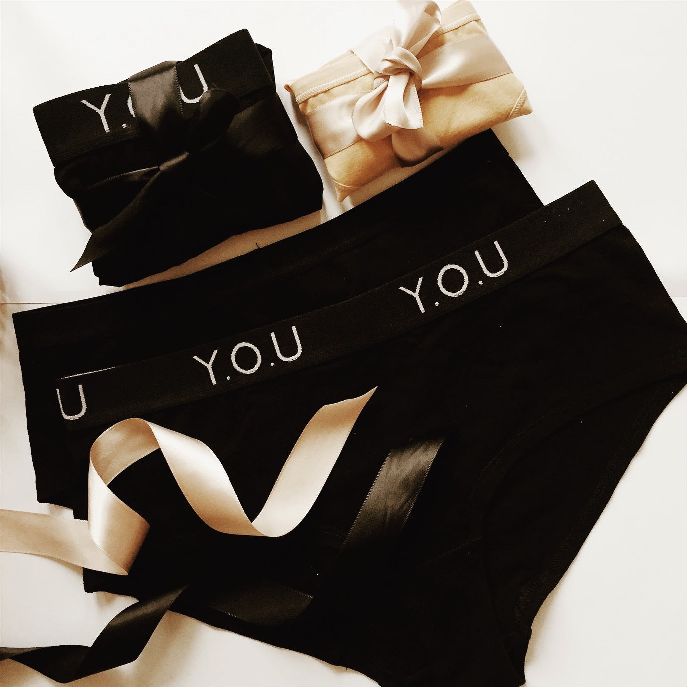 Y.O.U black bikini bottoms with gold ribbon.