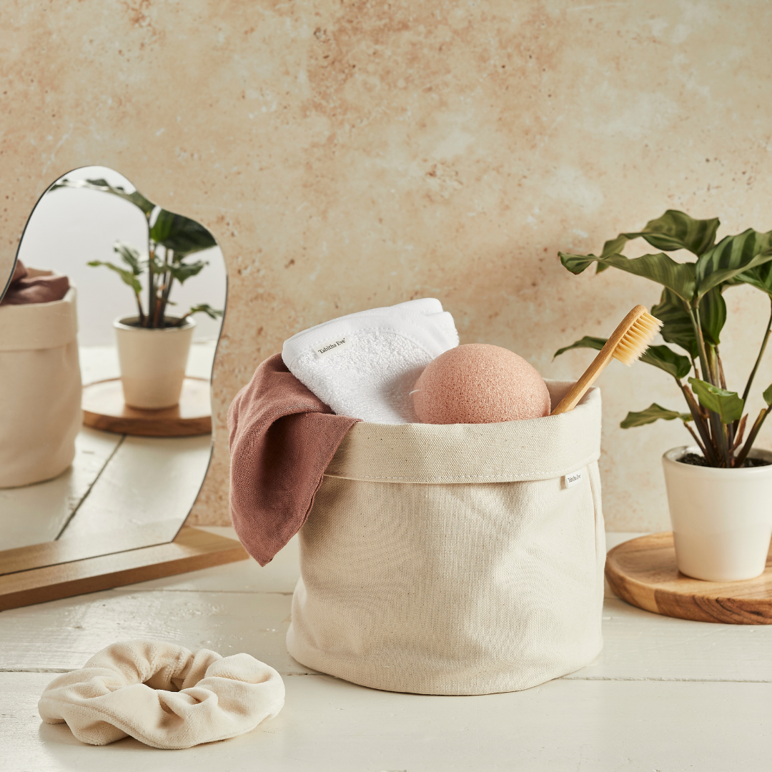 A small beige canvas bucket with bathroom essentials inside